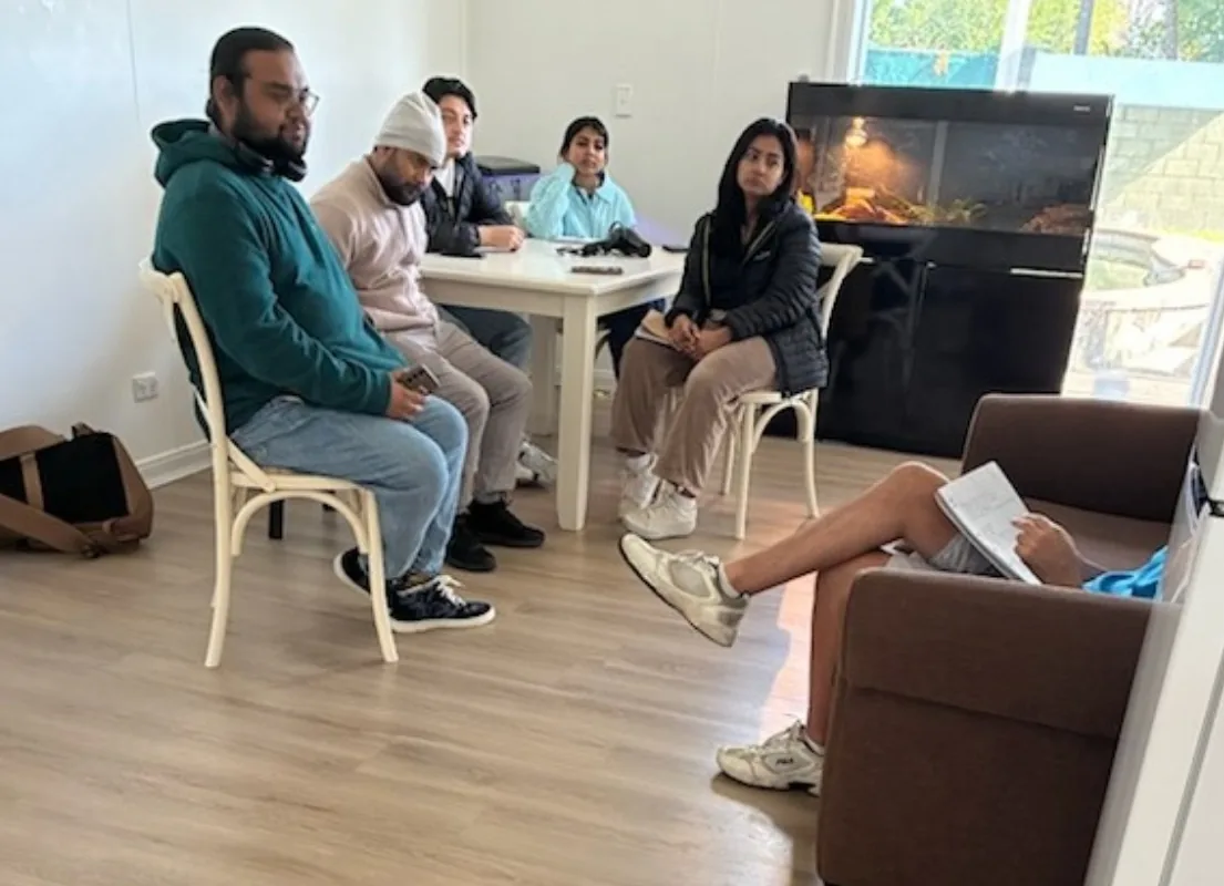 Students seated around a table in a meeting room